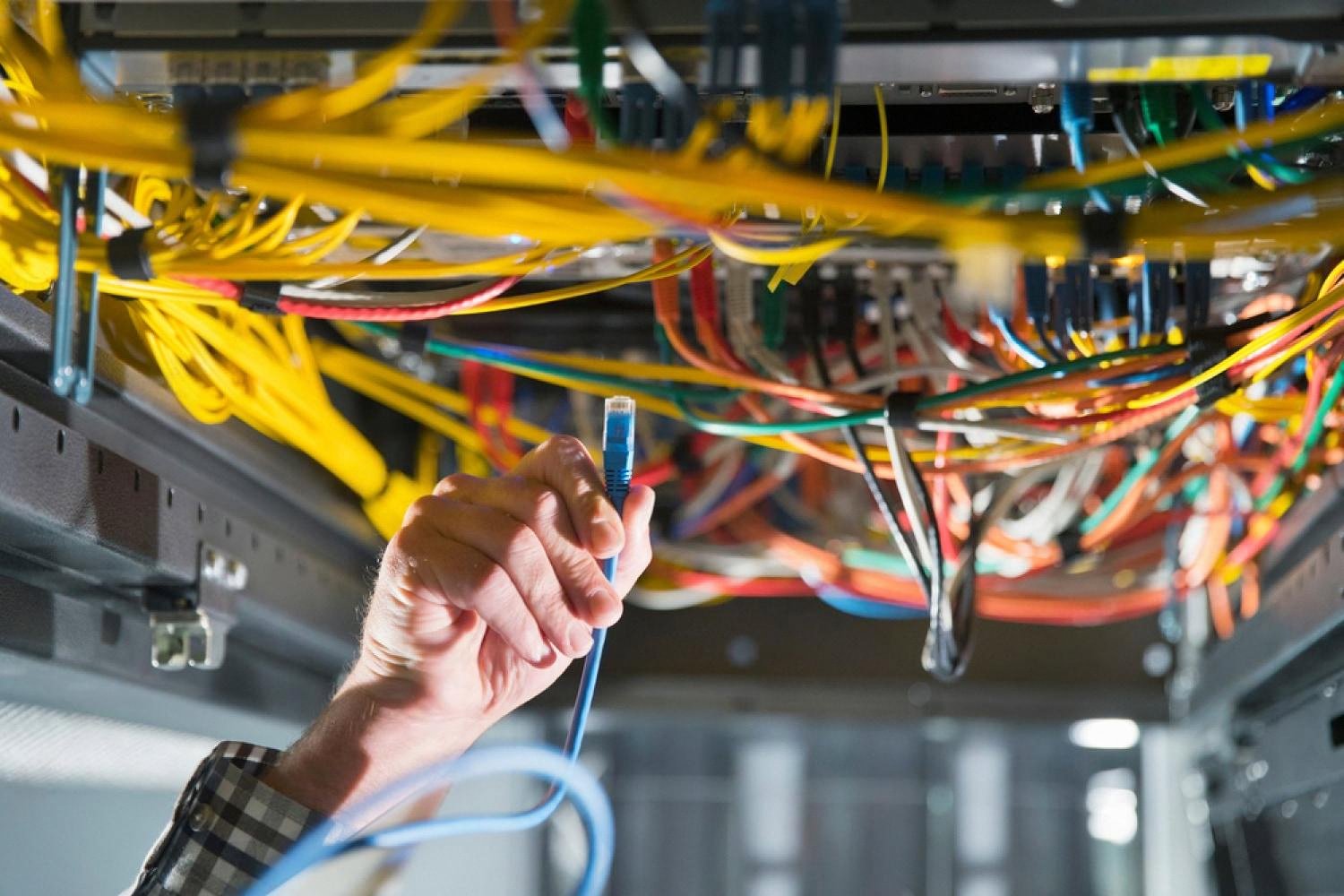 Technician handling network cables inside a UAE data centre server rack